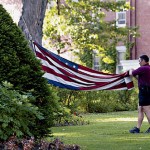 Now: (July) A Bates security officer folds the American flag at the end of a summer day.  Photograph by Phyllis Graber Jensen.