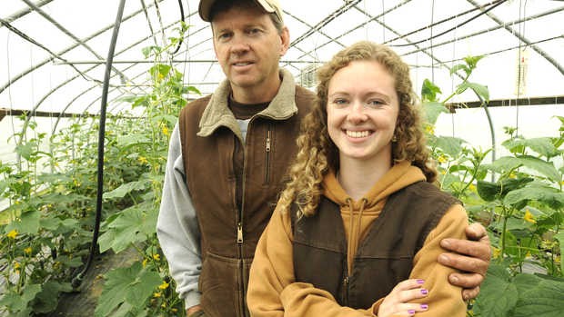 Tomi Chipman '14 stands with her father, Doug, in one of their greenhouses in Poland. Photograph by Jose Leiva/Sun Journal.