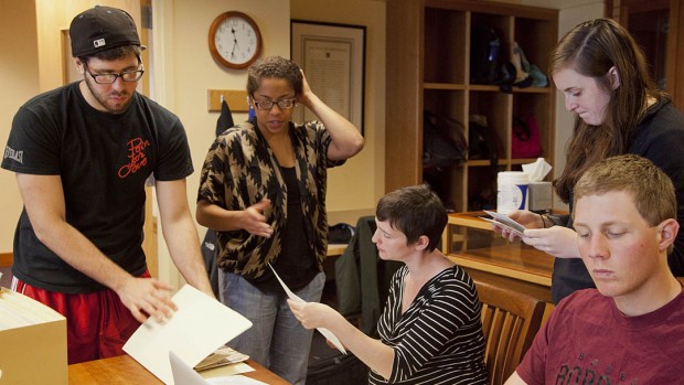 Students in the Short Term course "Making African American History: Preserving the Archives of the Portland NAACP" examine documents during a work session at the University of Southern Maine. From left: Joncarl Hersey '12, Tasheana Dukuly '12, professor Mollie Godfrey, Munroe Graham '13, Brad Reynolds '14. Photograph by Phyllis Graber Jensen/Bates College.