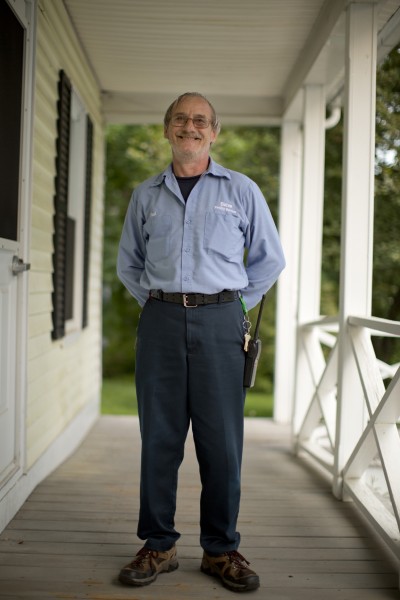 Facilities staffer Paul Michaud poses at on the porch of the Bates Communications Office. Photograph by Phyllis Graber Jensen/Bates College.