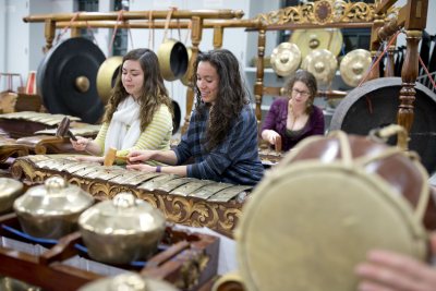 From left, Kinsey Moser'18 of Burke, Va., Jade Donaldson '18 of Wayne, N.J., and at rear, Janet Bourne, postdoctoral fellow in the humanities and music lecturer, rehearse on one of Bates' two sets of gamelan instruments in the Olin Arts Center. (Phyllis Graber Jensen/Bates College)