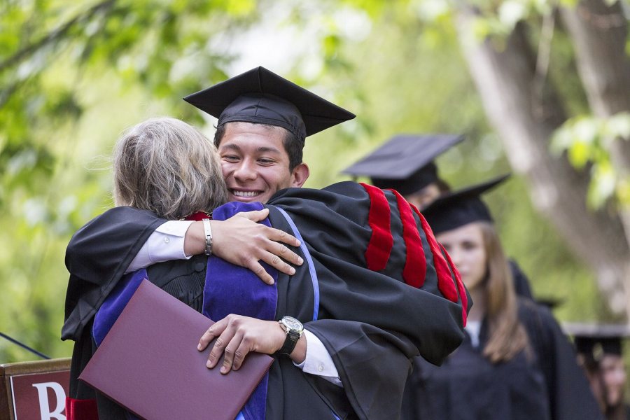 Norberto Diaz ’16 of Carson, Calif., receives a hug and a diploma from President Spencer. (Josh Kuckens/Bates College)