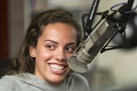 Olivia Bell '19 laughs with her co-hosts as she delivers a promotion.