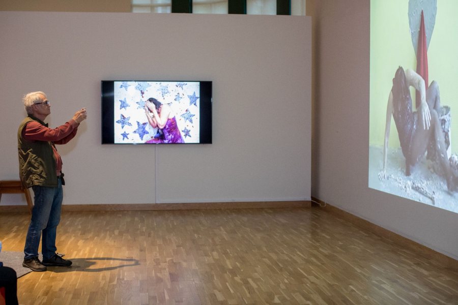 A visitor to the Bates Museum of Art takes in videos by, and showing, performance artist Kate Gilmore '97. Gilmore takes part in a Sept. 27 panel on performance art in conjunction with her exhibition In Your Way. (Rene Roy for Bates College)