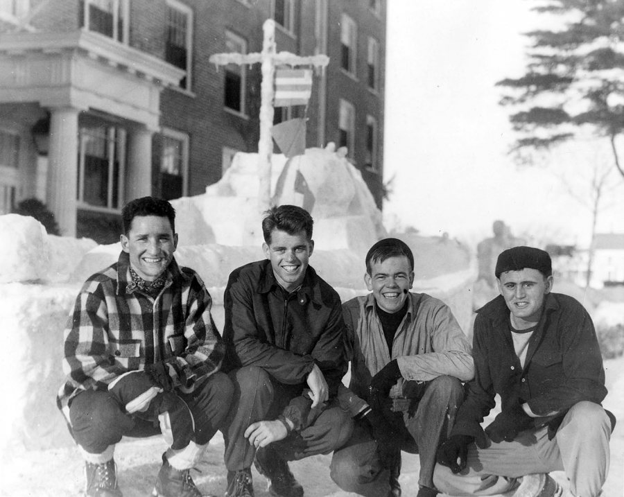 A member of the V-12 unit at Bates, Bobby Kennedy (third from left) poses in front of a Winter Carnival snow sculpture of a Navy ship. (Muskie Archives and Special Collections LIbrary)