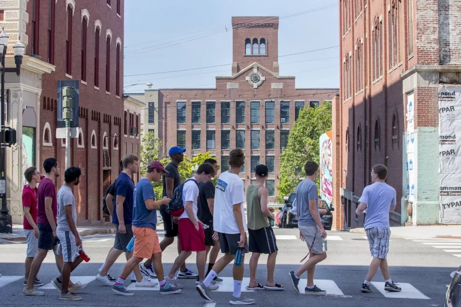 Walkabout leader Sam Findlen-Golden '20 of Amherst, Mass., leads first-year residents of Milliken House on Lisbon Street, as they pass the historic Bates Mill in the background.
.

Today, all members of the Class of 2022 visited their new home of Lewiston/Auburn with their First-Year Centers They were able to pick up their Class of 2022 tee-shirt and register to vote at the end of the walk, sponsored by the Harward Center for Community Partnerships. (Phyllis Graber Jensen/Bates College)