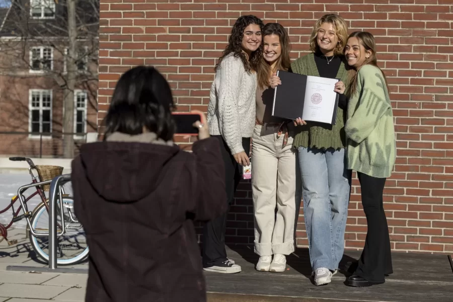 Ilana Rosker ’23 of Lexington,Mass.,(hat), a major in Hispanic Studies, and Emma Pike ’23 of York, Maine, a major in Hispanic studies, bind their theses in the company of friends on the Library Terrace on Dec. 13, 2022.
Rosker wrote on “La imagination, la rapture y la magia: Hacienda espacio para la conciencia alternativa a traves de la poesia Latin X.”
Pike wrote on “Llimpia bus propoios Platos!: explorando masculinidad hegemonica en Jane the Virgin.”