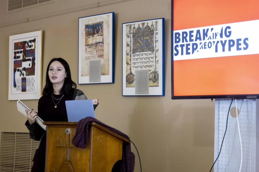 Frances White of ’23 New York City presents her religious studies senior thesis, “Women With Chutzpah.” to members of Temple Shalom Synagogue-Center in Auburn after a brunch on Sunday, Feb. 12, 2023.

“I just knew I wanted to work on something that was going to be funny and enjoyable and also kind of empowering and important to myself.”

— Frances White ’23 of New York City

Champagne and Coca-Cola sprayed in unison as a group of White’s friends gathered outside Ladd Library on Monday, Dec. 12, 2022, to watch White and her friend, Fenna Oliphant-Linden ’26 of Bethesda, Md., bind White’s thesis in religious studies, titled “Women with Chutzpah.”

“Women with Chutzpah” is about “the subversive means of Jewish humor for Jewish women specifically,” says White, who looked at five female Jewish comedians for her research: Sophie Tucker, Toby Fields, Gilda Radner, Ilana Glazer, and Tiffany Haddish.

“It was a way for me to just take what I love doing, which is making people laugh and using coping mechanisms of humor, and then seeing how that works in scholarly discourse.” White’s thesis adviser is Professor of Religious Studies Cynthia Baker.

White is also minoring in Africana, and her studies around the concept of race helped inform the focus of her thesis.

“A big part of my thesis was looking at how making fun of identity and humor is different if it's your identity, rather than someone else's.” It’s one thing when Jewish women themselves reclaim their pride in a Jewish body, White said, “but when other people are saying or using these stereotypes, it holds a very different impact.”

“How do we as Jewish women talk about ourselves and then use that as empowering, while also acknowledging we know what the anti-Semitic discourses are.”