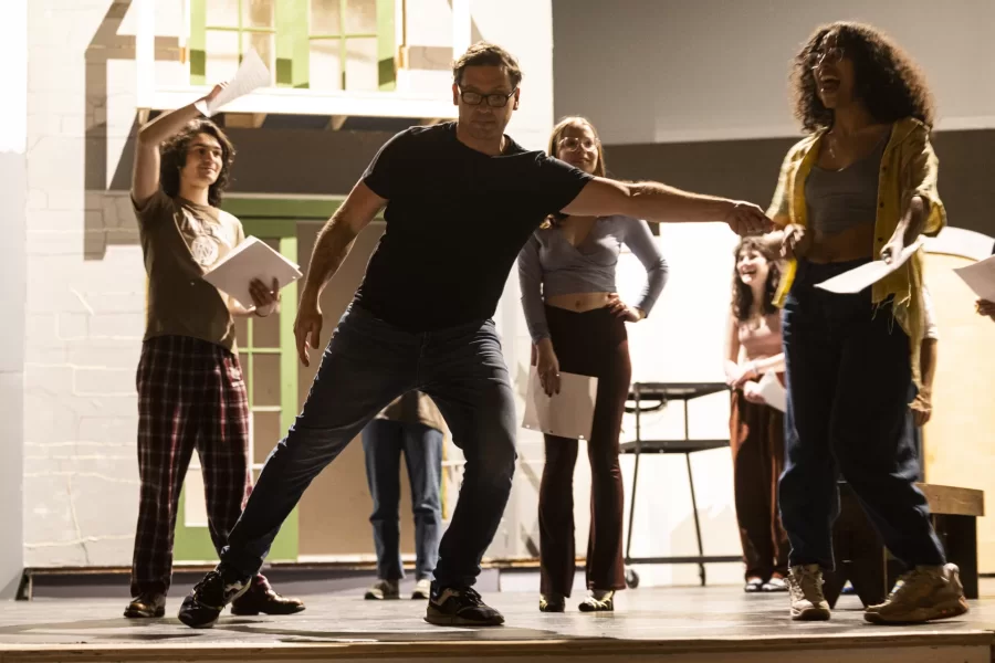 Mia Bernstein ’23 of Bedford, Mass., teaches a dance to actors in Shakespeare’s “Much Ado About Nothing” directed by Assistant Professor of Theater Tim Dugan on the stage of Schaeffer Theatre on Feb. 16, 2023. Stage Manager Lucie Green ’23 of Pittsburgh is also shown in action, seated and moving throughout the theater seats.