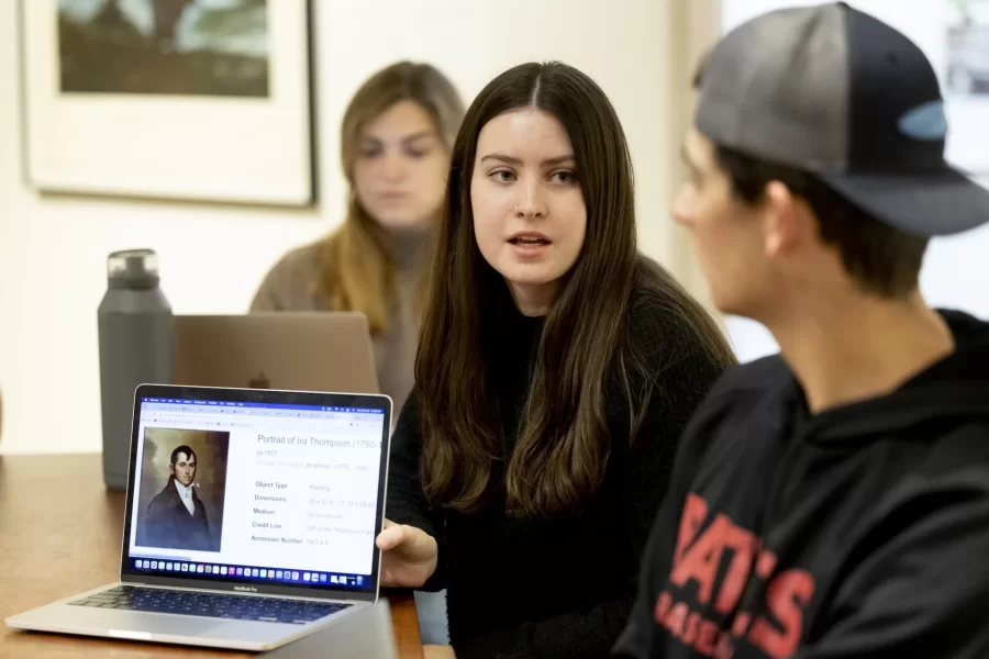 Historical Methods class, taught by Associate Professor of History Caroline Shaw, meets in the Lower Gallery of the Museum of Art in the Olin Arts Center. Working with Peter Philbin í22, assistant museum curator, the students broke into several groups to consider four works of art, and how they would use that artwork along with other pieces in the museum collection, to create an exhibition.

HIST 399 - Historical Methods
This seminar refines students' proficiency as historians and prepares them to write their senior thesis. The course is designed around two interrelated goals. First, students analyze how different approaches to history and sources matter to understandings of the past. Second, students design and test their own arguments, drawing upon critical readings of primary sources and close engagement with historiography. The course culminates in the completion of individual thesis proposals. Prerequisite(s): one HIST 301 seminar.

Students at table, from head of the table, left:

Hanna Matthews í24, brown sweater, long blonde hair
Matt Connelly í24, white shirt
Chris Ly í24, black hoodie
Emily Everett í24, light gray sweater
Bridget Lee í24, gray sweater, brown pants
Ben Fasciano í23, gray sweater
James Guinee í24,blue/green sweater
Ned Farrington í24, blue flannel
Sebastien Kleitman í24, black hat
Luke Linnehan í24, black baseball hoodie and hat
Campbell McKendry í24, black sweater, brown hat
