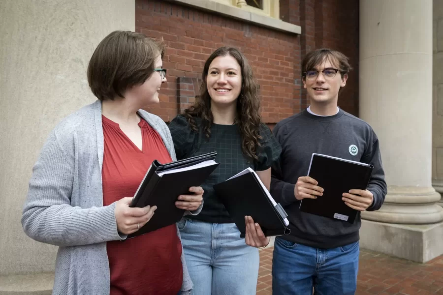 “My thesis is about the evolving role of French in Maine, and as a Franco-American and French speaker, Herb has been a great friend and contributor to the brainstorming process surrounding my thesis.”

Martha Coleman ’23 of Seattle, a double major in French and Francophone studies and American studies, took to the steps of Coram Library to bind her honors thesis, along with other students, staff, and faculty.

Coleman recruited the help of Herb Saucier, the Learning Shuttle bus driver for the Harward Center for Community Partnerships, to bind her thesis, titled “Le français et le Franco(phone)s: An exploration of the evolving significance of French in Maine,” advised by Professor of French and Francophone Studies Mary Rice-Defosse.

“Over the last four years, I've gotten to be here and speak this language, and speak it with people who grew up here speaking French,” she said.

Saucier has been a “supporter and cheerleader” for Coleman throughout the thesis writing process. “I just think it's such a nod to how important community work and community members have been to this project.”

“Community engagement has been a huge part of my time at Bates and I hope that my thesis binding will be an opportunity to recognize and celebrate the community members who made my thesis project, and my Bates career as a whole, possible,” says Coleman.

Allison Fischman ’23, a sociology major from Woodbridge, Conn., and Sam Manogue ‘26 of Wynnewood, Penn., were binding Fischman’s thesis, titled “Adverse Childhood Experiences (ACEs): Conceptualizations in Research and Policy,” advised by Professor of Sociology Emily Kane.

Liam Daly-Smith ‘23, a physics major from Montclair, N.J., got help from Jing Fang ’23 of Beijing, and Adriana Pastor Almiron ’25 of Asuncion, Paraguay, to bind his thesis, titled “Tidal Energy in Cobscook Bay: An Analysis of Tidal Range Energy and Tidal Barrage Generation Paradigms,” advised by Professor of Physics John S