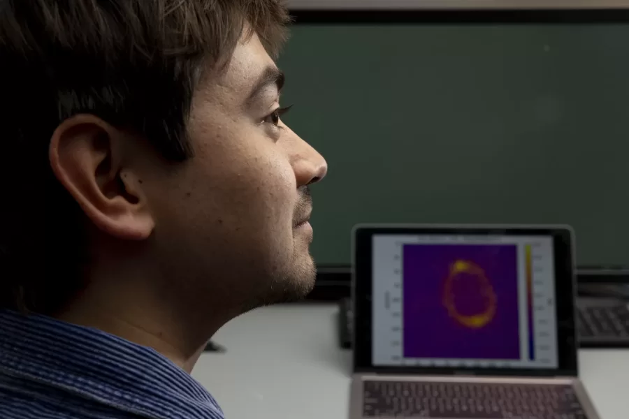 Professor of Physics Nathan Lundblad has received an award from NASA. He is collaborating with several students on the research and is shown here in his Carnegie Science Lab (Carnegie 146) with two of those students, Kona Lindsey ’23 of Colorado Springs, Colo., and Elias Veilleux ’23 (I gray shirt with glasses) of Orono, Maine

Kona is shown with his laptop that display research images. Kona writes: “The image seen on my laptop is from an experiment run in the Cold Atom Lab on the International Space Station (ISS). It shows an ultracold gas bubble composed of rubidium atoms. The ring that is visible indicates that the atoms are occupying a shell, or bubble structure. You can see that the inside of the ring has few atoms, meaning the structure is truly hollow.”