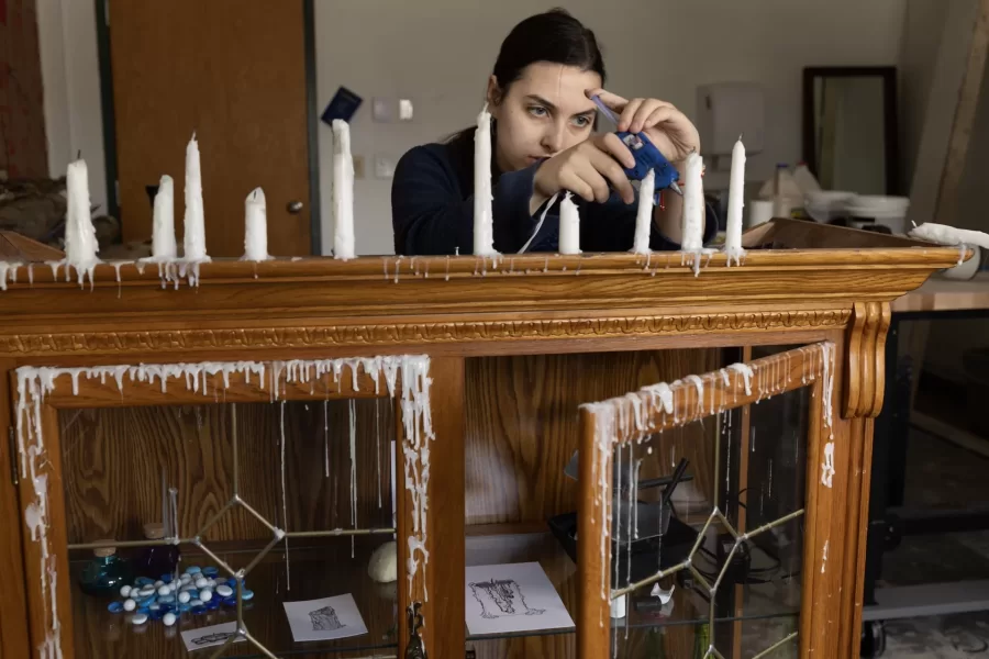 Olivia Rabin ’24 of Montclair, N.J., works in her Olin Arts Center studio on March 21, 2024.

From a young age, I was fascinated by nature and the fantastical. This and the works by people similarly inspired by the natural world inspire my current work. While I am interested in many different things, I am always working to visualize them to help me understand how I connect them internally. In my work, I am trying to synthesize my own process into something tangible and observable. I am exploring the connections between my headspace, the act of expression, and the physical world.

I want to explore the emotions and sensations of the world around me, being captivated by nature and the fantastical. I love the mysterious blues and otherworldly qualities of water, especially found in oceans and waterfalls. I am thoroughly enchanted by them. This was only heightened by my favorite creative works like The Blue Planet by David Attenborough. This film not only allowed me to see the ocean’s depths in ways I had never seen before but also showed me ways in which form can create fantastical emotions out of the real. Works like Hayao Miyazaki’s Laputa: Castle in the Sky expand on this in artistic and sensory ways that become their own mythology. Works by artists like Heikala and Gabriel Picolo expand upon mundane elements of reality, abstracting them into the fantastical. Heikala’s illustrations often explore the magic in mundane moments by abstracting an element like size, time, or location to convey an emotion fantastically. In Picolo’s Icarus and the Sun, the already metaphorical wax of Icarus’ wings becomes more emotional as Icarus’s body is made of wax and the sun becomes his lover. Wax is quite captivating for me as its qualities are intrinsically related to water. Wax flows like water but as it cools and solidifies it almost freezes a moment in time and space allowing for the magic to be captured. In these works, I was able to find connections between my int