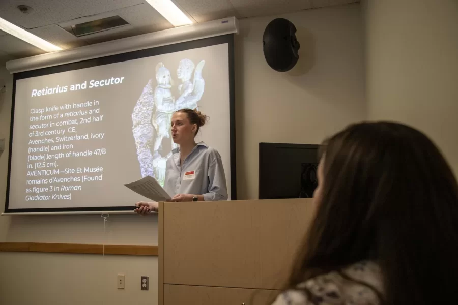 Classical & Medieval Studies professor Liana Brent watches as Julia Neumann '25 presents on enslaved Roman gladiators as part of a panel on Roman slavery by students of Brent's Fall 2024 course, Slavery in Ancient Rome.