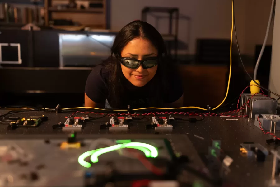 Assistant Professor of Physics Ryan Cole works with students in his Carnegie Science 156 lab on June 20, 2025. There is a secondary lab pictured in some of the photos that he and Paloma visited wearing goggles, where they used a laser to measure light frequencies. 

“Every once in a while, science makes sense,” he said at one point to the students.



“Paloma is building an instrument to study very precisely sunlight and specifically the spectrum of sunlight for applications ultimately in exoplanets (planets orbiting other stars)  detection and characterization.

And then this table, which is Carson, Quinn, and Audrey (and Andrew Liu who is not here today) They are measuring how atmospheric gases like methane — specifically green house gases — interact with light to ultimately help us measure those things better in the atmosphere.

Students photographed:

Audrey Schane ’25, physics major, who is working as a research assistant with Cole this summer,
Shown at the computer (striped t-shirt), where she is looking at a gas sample where she’s building something to control gas temperatures, with a vaccuum on the bottom. 

Paloma Rodriguez ’26, a physics major (black t-shirt)

Carson Moellering ’26, physics major, looking at how methane absorbs light in different conditions (light reflecting back and forth in mirrors (white t-shirt)

Qwynn Kobertz ’26, double major in physics and studio art, using a DSR laser exploring how to use this laser in a methane detecting app. (sunglasses on head) Here are two quick links that may help with some context for what we're doing in the lab.

My research website: https://sites.google.com/bates.edu/colelab/research-areas?authuser=0

NIST Article on optical frequency combs: https://www.nist.gov/topics/physics/optical-frequency-combs