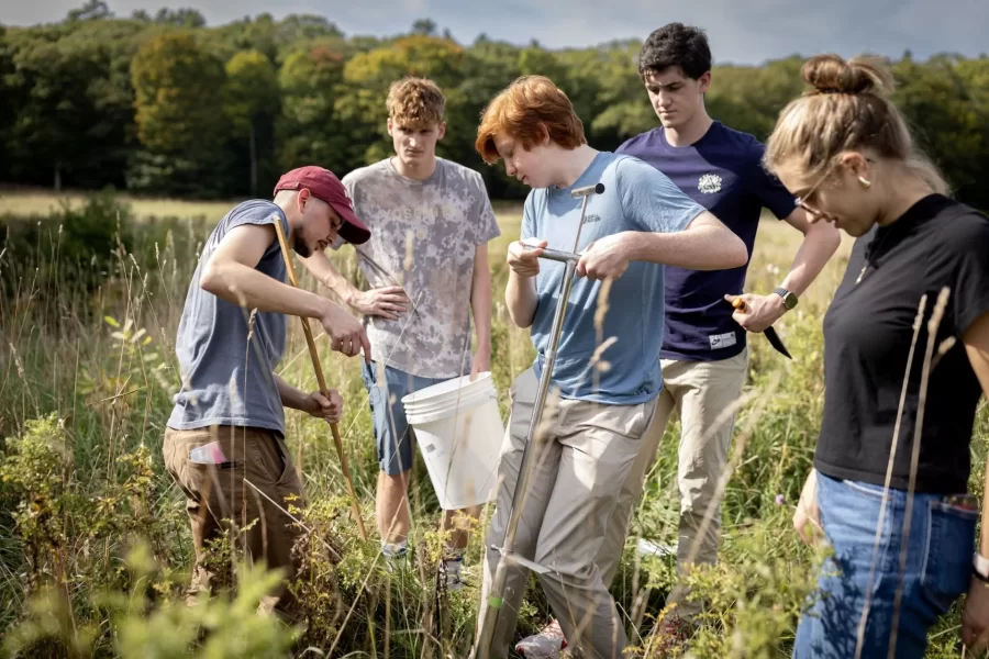 Bates biology students have joined as effort at an organic farm in Freeport to work through the complex issues of soil contamination by PFAS, so-called forever chemicals, caused by the spread of contaminated sludge as fertilizer decades ago.

Here, post-baccalaureate scholar Sebastián León Fallas ’24 (left) is teaching students how to collect a soil core sample. From left, León Fallas, Trent Hieber ’26 of Granby, Conn., John Harun-Delong ’26 of Fairbanks, Alaska, Ben Leach ’27 of Atlanta, and Bryn Murray ’27 of Jupiter, Fla., who is a course teaching assistant.

Laura and Winslow Robinson, owners and operators of Fable Farm, have invited scientists at Bates and Yale University to do grant-funded research to better understand the effects of PFAS on farm and to find scalable solutions to the crisis.

The Bates students are in the course “Biological Research Experience: Molecules to Ecosystems,” taught by Levi Adams, a lecturer in biology. It’s the type of Bates course that engages students in hands-on research experiences, teaching them how to apply various research methods using multiple approaches that span a range of disciplines in biology, from molecular to ecological.