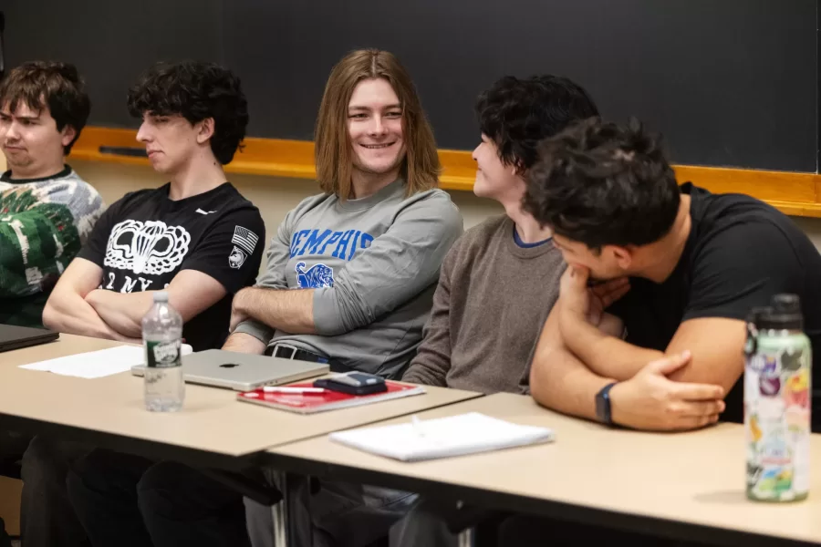 Students sitting at a table discuss amongst themselves during a class in Pettengill Hall.