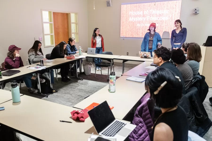 Two students stand at the front of the room, giving a presentation to their class in Pettengill Hall.