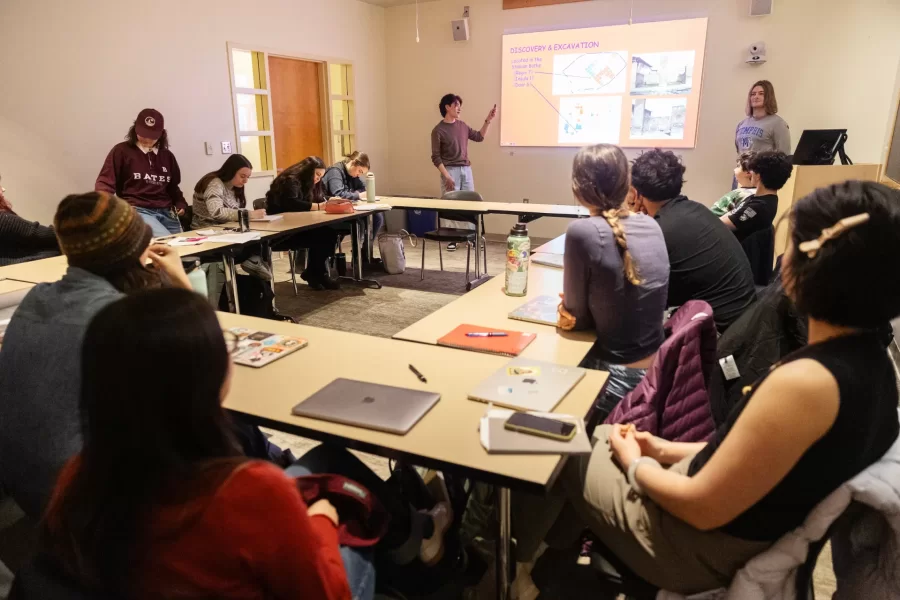 Two students give a presentation to their class on discovery and excavation in Pettengill Hall.