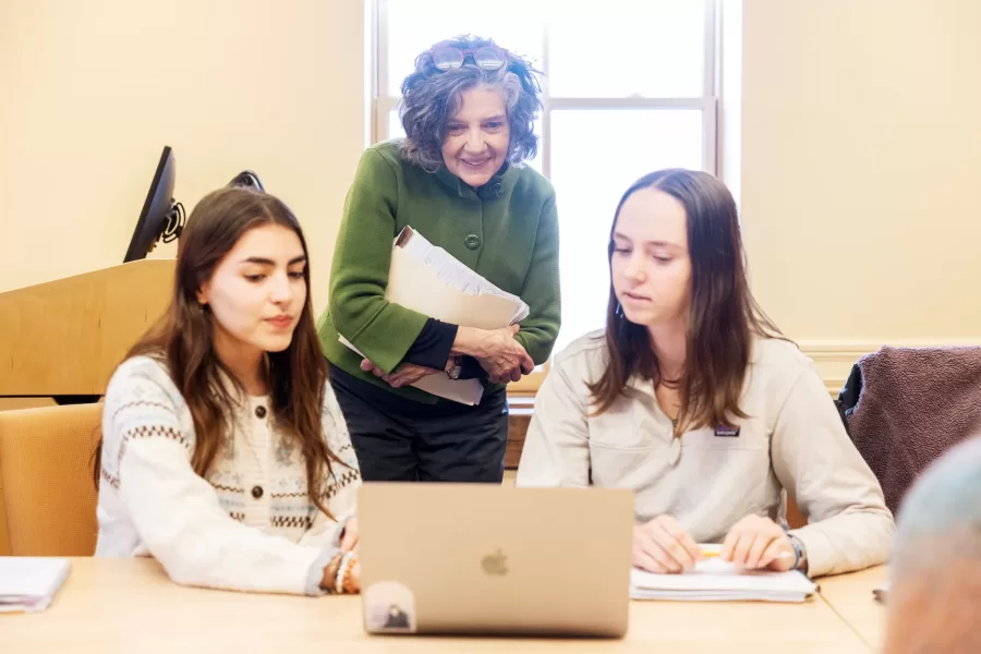 Two students share work on their computer with their professor during Race and Tobacco class in Roger Williams Hall.