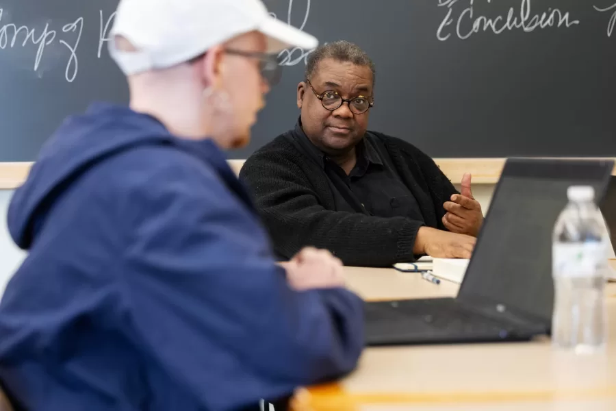 A student engages in discussion with their professor during American Studies class in Pettengill Hall.