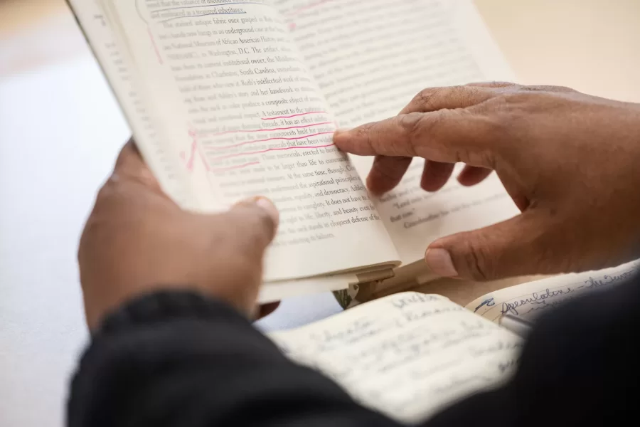 Associate Professor of American Studies reads from an annotated book to his class.