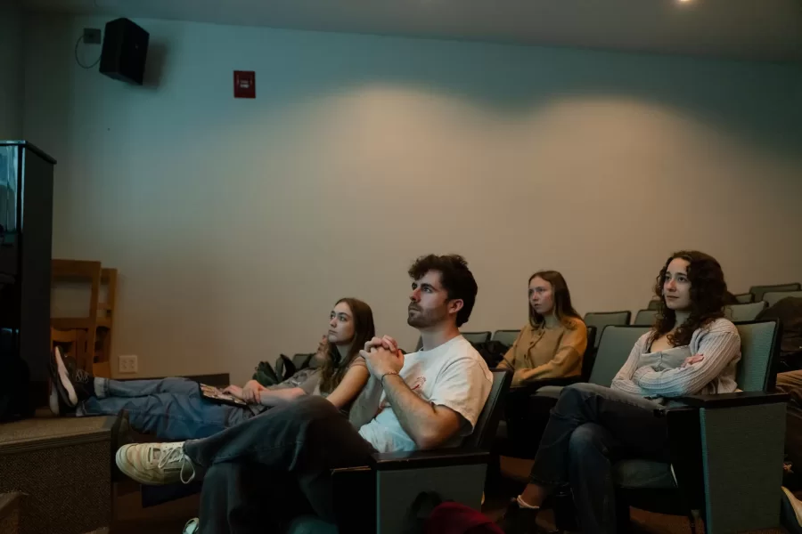Lewiston, ME, United States  -- Students watch the film, “Say Cheese!” by Bates alum Amy Geller `96, during a Film Festival Studies taught by Professor Jonathan J. Cavallero in Olin Arts Center 105 at Bates College in Lewiston, ME on Wednesday, March 25, 2026. Students discussed whether they should show the film at the upcoming festival and issues with copyright over the music that is used in the film. (Photo by Yoon S. Byun) © 2026 Strewn Wonder, LLC