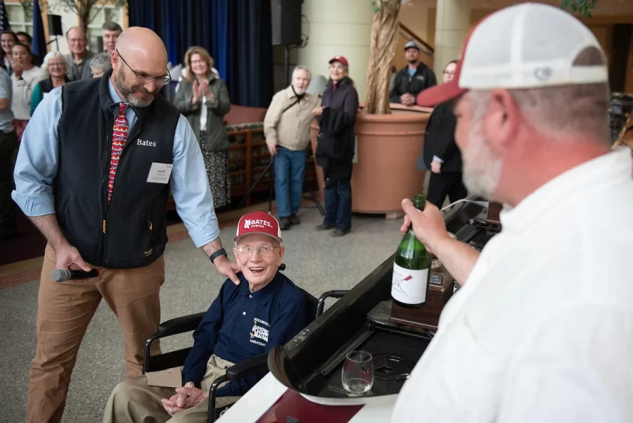 Ralph Sylvester ’50, center, thanks Bates Rowing Head Coach Peter Steenstra, right, after christening the new rowing shell at Perry Atrium in Pettengill Hall on April 29, 2023. Coach Steenstra presented Sylvester with a blade during the dedication ceremony making Sylvester the only non-rower to receive one.