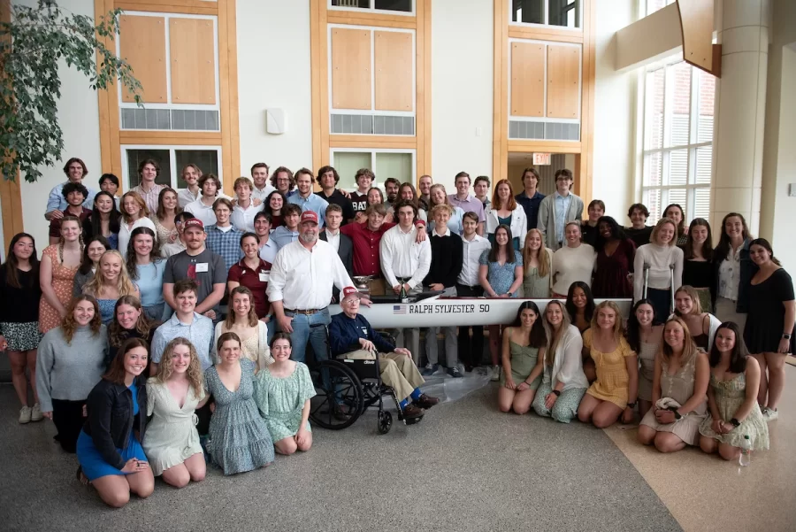 On Saturday April 29, 2023 at Perry Atrium in Pettengill Hall Bates alumnus ’50 Ralph Sylvester posed for a photo with the Bates Men and Women’s rowing teams following the christening of the new rowing shell which was dedicated to him. Bates Rowing Head Coach Peter Steenstra presented Sylvester with a blade during the dedication ceremony, making Sylvester the only non-rower to receive one.