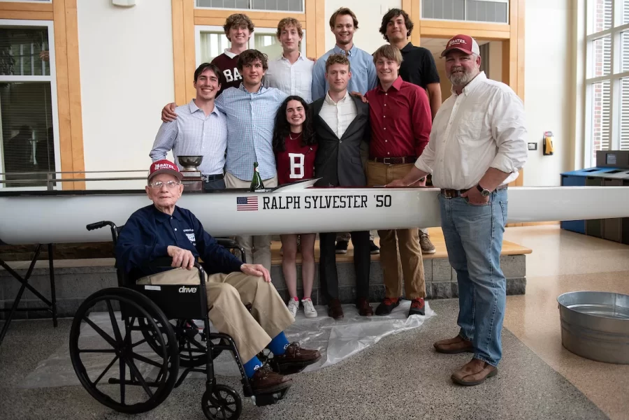 On Saturday April 29, 2023 at Perry Atrium in Pettengill Hall Ralph Sylvester ’50 posed for a photo with members of the Bates Men and Women’s Rowing team following the christening of the new shell which was dedicated to him. Bates Rowing Head Coach Peter Steenstra presented Sylvester with a blade during the dedication ceremony, making Sylvester the only non-rower to receive one.