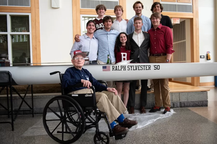 On Saturday April 29, 2023 at Perry Atrium in Pettengill Hall Ralph Sylvester ’50 posed for a photo with members of the Bates Men and Women’s Rowing team following the christening of the new shell which was dedicated to him. Bates Rowing Head Coach Peter Steenstra presented Sylvester with a blade during the dedication ceremony, making Sylvester the only non-rower to receive one.