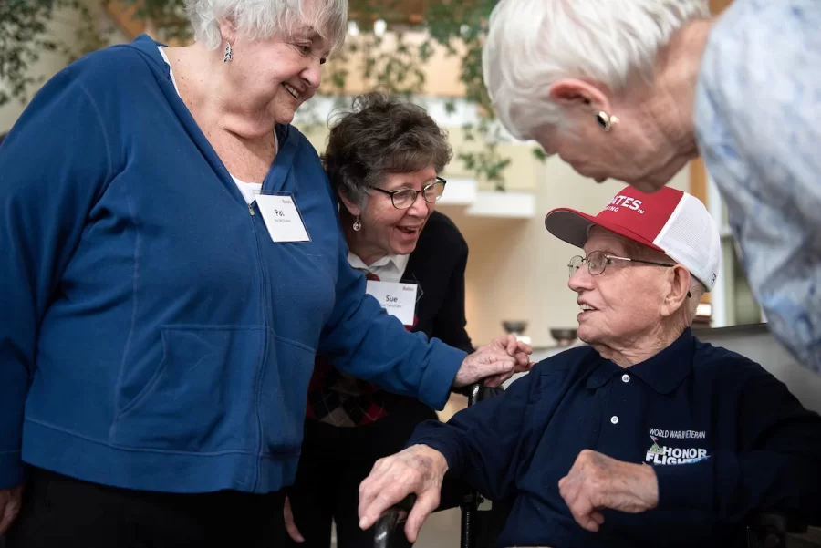 Pat McCluskey of Peru, left, Sue Tymoczko of Lewiston and Cindy Peters of Lewiston congratulate friend Ralph Sylvester ’50 during the dedication of the new rowing shell at Perry Atrium in Pettengill Hall on April 29, 2023. Tymoczko, McCluskey and Peters were teachers at Edward Little High School where Sylvester’s late wife worked.