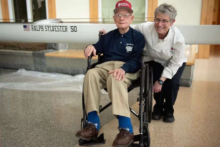 Ralph Sylvester ’50, left, poses for a photo with Associate Vice President for Dining, Conferences, and Campus Events Christine Schwartz during the dedication of the new rowing shell at Perry Atrium in Pettengill Hall on April 29, 2023.