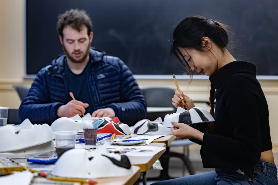 Provided with blank masks and prepared Chinese watercolor paints and brushes, six Chinese language students, led by Learning Associate in Chinese Veronica Huang, recently gathered around a Roger Williams Hall table to create the traditional faces of Peking Opera masks.

The students were able to use pictures of Peking Opera masks provided by Huang as a reference. Or they could design their own.

According to Huang, “Different face colors represent different characters and personalities.” For instance, the color red on a mask represents the character wearing it as “brave and loyal.”

Huang worked alongside the students to make the masks in other colors too. “By making these Peking Opera masks, students can experience traditional Chinese Opera culture more vividly,” she says, “which will have a positive impact on their learning of Chinese language and culture.”

Sheila Robledo ‘25, Alex Sandvil ‘27, Alex Takeyh ‘26, Cora Zuwallack ‘27, Myat Htut ‘27, and Vova Sosnovskii ‘26 wound down a busy week with the creative activity. Huang plans to decorate the Chinese department’s hallway with their efforts.