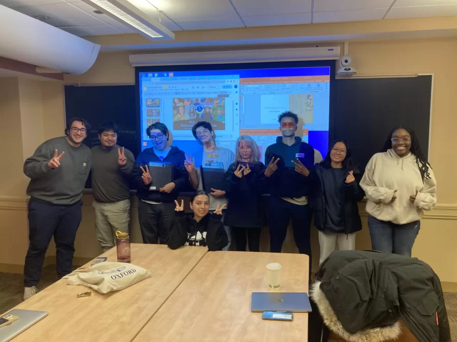 Ulyses Hernandez Felipe ('24), Teddy Duval ('24), and Lendro Hu ('24) hold their completed, bound thesis manuscripts alongside all of their Asian Studies Senior Seminar classmates.