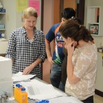 TWA Missy Ducommun '11 goes over comments on a draft Introduction with a group in lab.