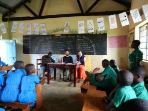 Conor Smith (center at table) moderates a student conservation education debate at Kasiisi Primary School in Uganda.