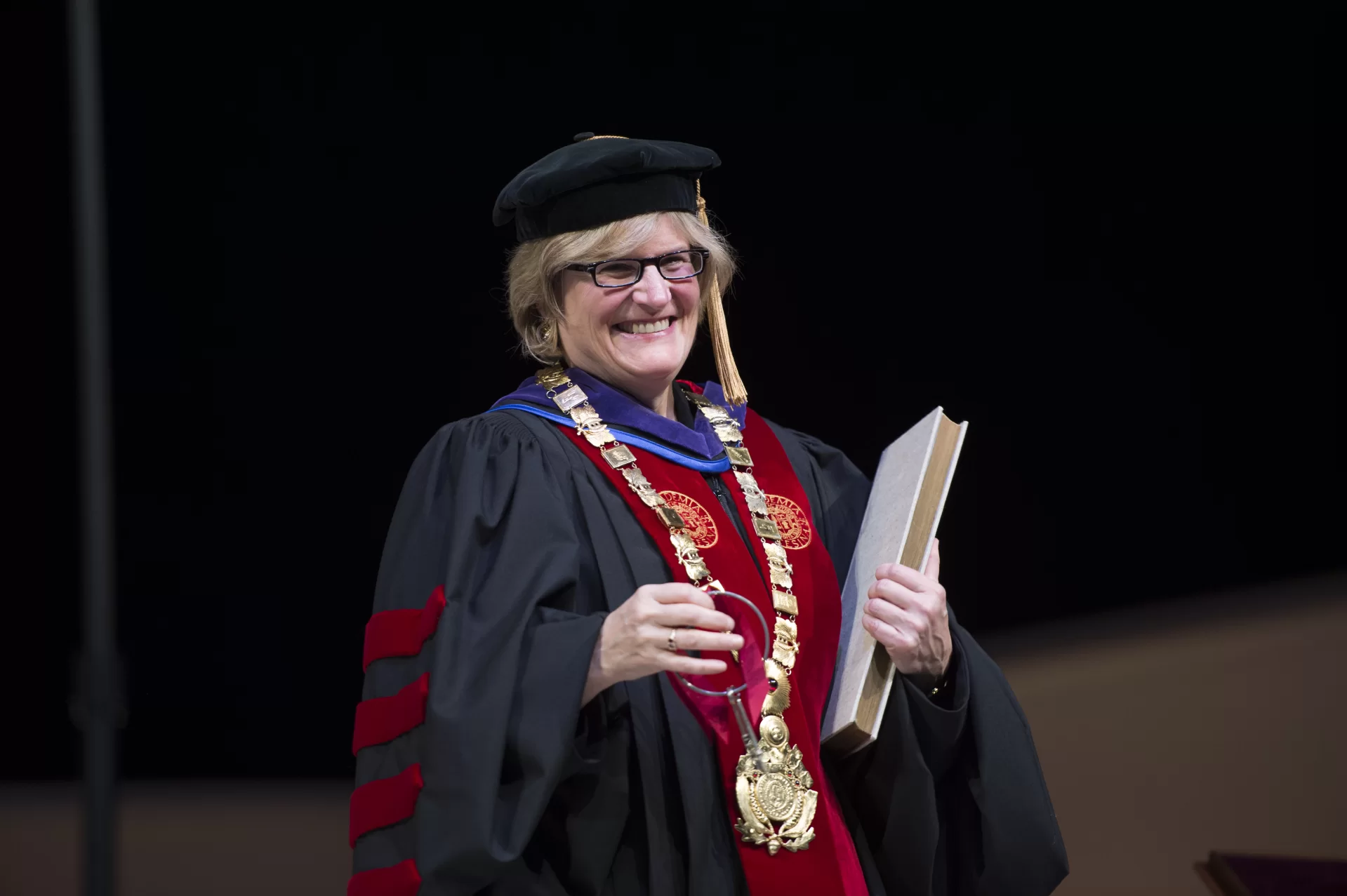 Clayton Spencer holds the symbols of office during her installation ceremony as the eighth president of Bates College on Friday, Oct. 26, 2012. The symbols are the keys, the presidential collar, and the record book.