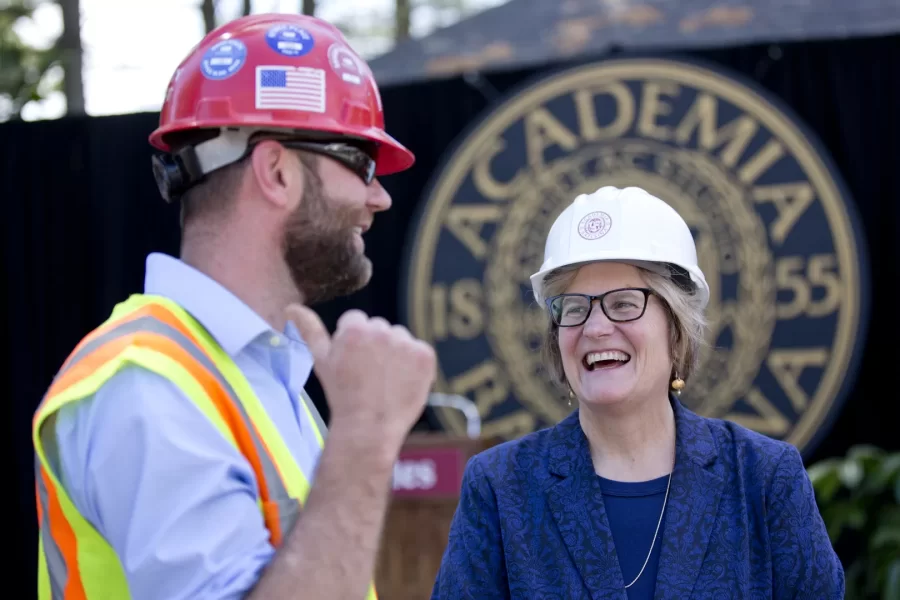 Spencer participates in a topping off ceremony for construction of two new residences on Campus Avenue in June 2015.