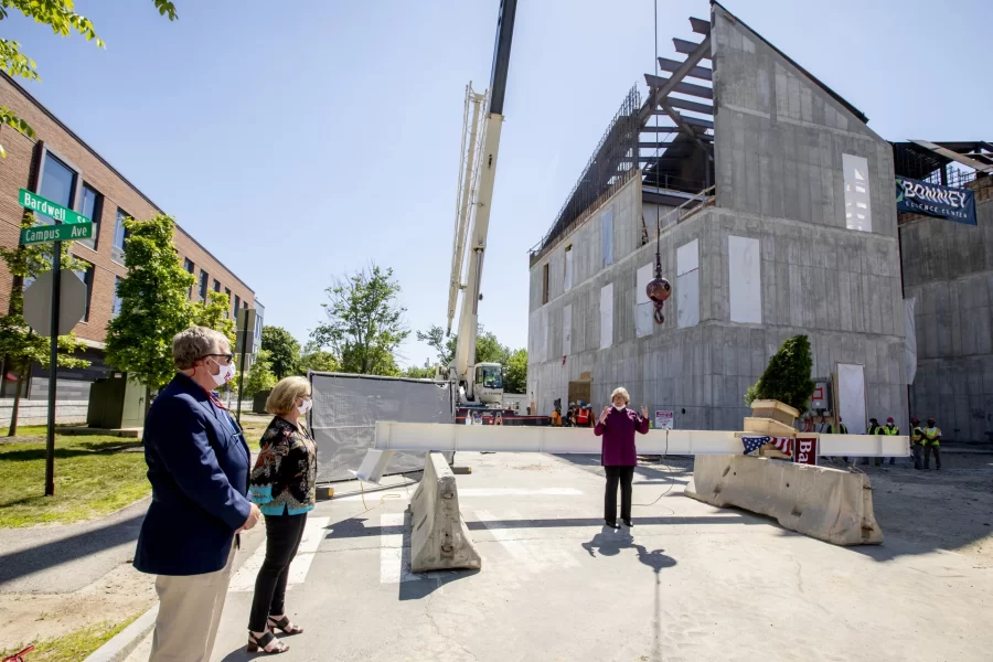 Spencer speaks at the physically distanced topping-off event for Bonney Science Center on May 16, 2020. At left are Michael Bonney ’80 and Alison Grott Bonney ’80.