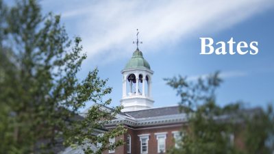 Hathorn Hall with blue sky surrounded by greenery with white Bates wordmark