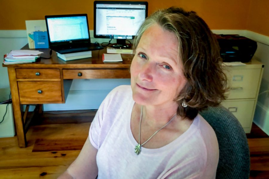 Lecturer in Digital and Computational Studies and Programmer Analyst Maureen Haining poses in front of her computer in her Rockport home.