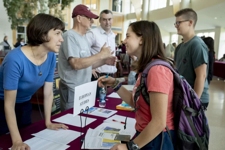 Associate Professor of German Raluca Cernahoschi speaks with first-year student Elliott Vahey of Shaker Heights, Ohio, while Associate Professor of Russian Dennis Browne and Associate Professor of German Jakub Kazecki talk with Ollie Young '23 of Burlington, Vt., during an Academic Fair in Pettengill Hall's Perry Atrium. For three hours this morning, faculty spoke with members of the Class of 2023 about their departments' offerings.