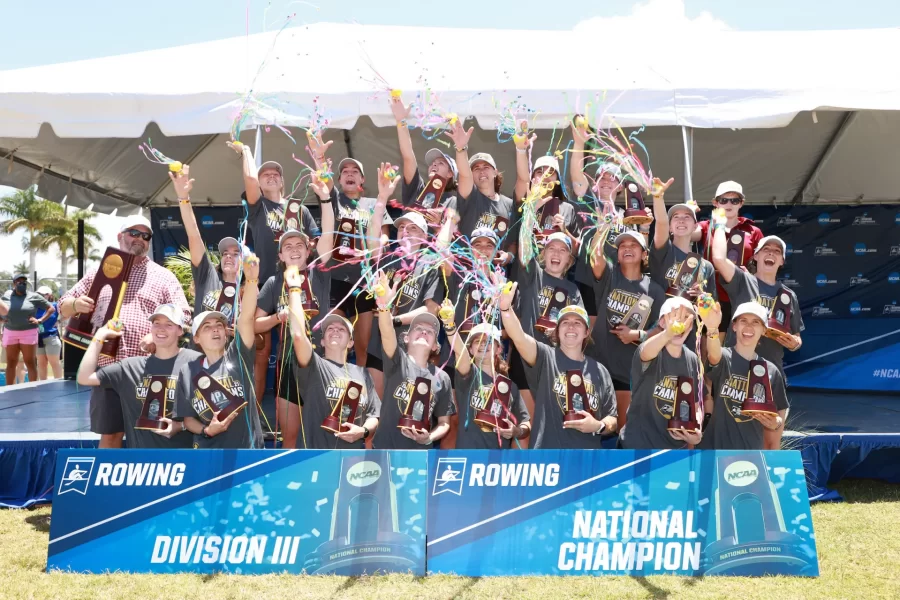 The Bates women's rowing team poses with their championship trophies and throws celebratory confetti.