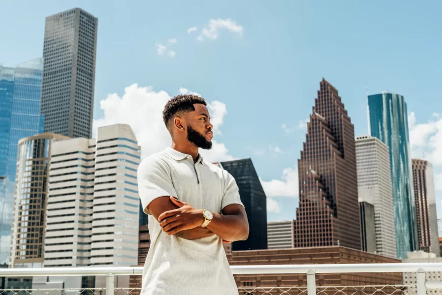 A student poses in front of the Houston skyline.