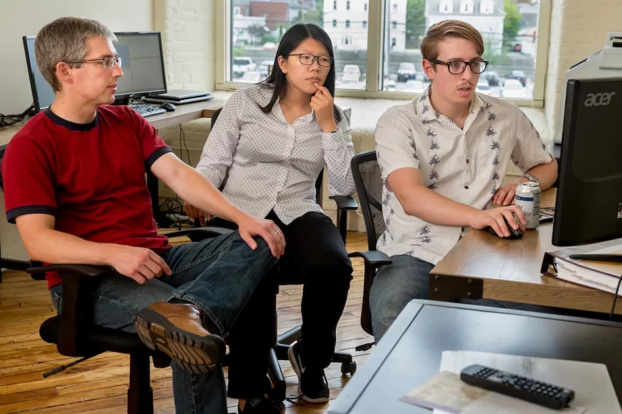 From left, Associate Professor of Economics Nathan Tefft meets with his Purposeful Work interns Fan Dong ’17 of Beijing and Michael Varner ’17 of Chelsea, Mich, in the offices of Looking Glass Investments in the Fort Andross Mill in Brunswick. Tefft is executive vice president and chief economist for LGI, a firm that invests in peer-to-peer lending. (Phyllis Graber Jensen/Bates College)