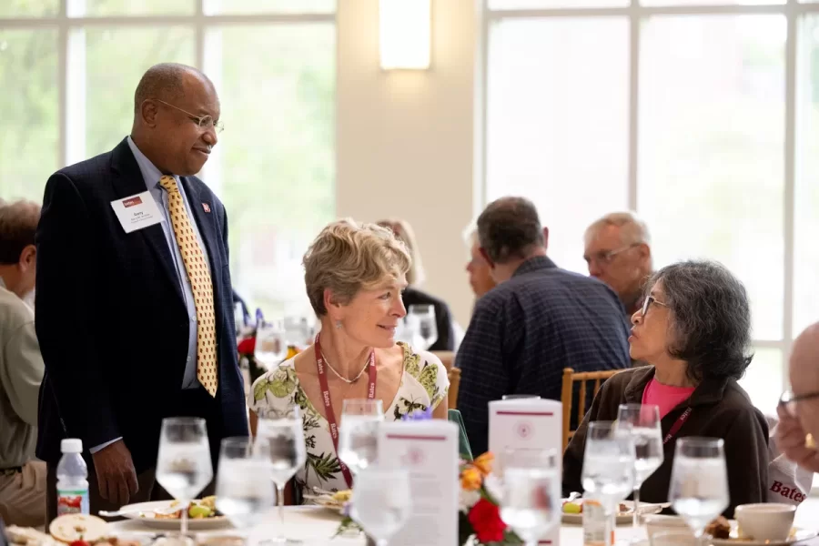 President Garry W. Jenkins addresses members of the Class of 1975 at their 50th Reunion Breakfast in Pettengill Hall’s Perry Atrium on June 6, 2025. He presented to awards: one, Bates Best,  to Susan Bourgault Akie ’75 P’08, and the other. The 2025 50th Reunion Philanthropic Leadership Award, posthumously, to John R. Hester ’75 whose brother Andy Hester (in green), nephew and Andy’s son Geoffrey Hester, John’s brother Mike Hester (in brown) with John’s wife Bronwen, accepted the honor.