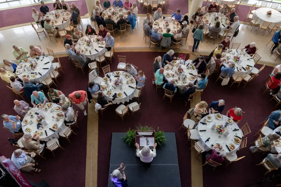 President Garry W. Jenkins addresses members of the Class of 1975 at their 50th Reunion Breakfast in Pettengill Hall’s Perry Atrium on June 6, 2025. He presented to awards: one, Bates Best,  to Susan Bourgault Akie ’75 P’08, and the other. The 2025 50th Reunion Philanthropic Leadership Award, posthumously, to John R. Hester ’75 whose brother Andy Hester (in green), nephew and Andy’s son Geoffrey Hester, John’s brother Mike Hester (in brown) with John’s wife Bronwen, accepted the honor.