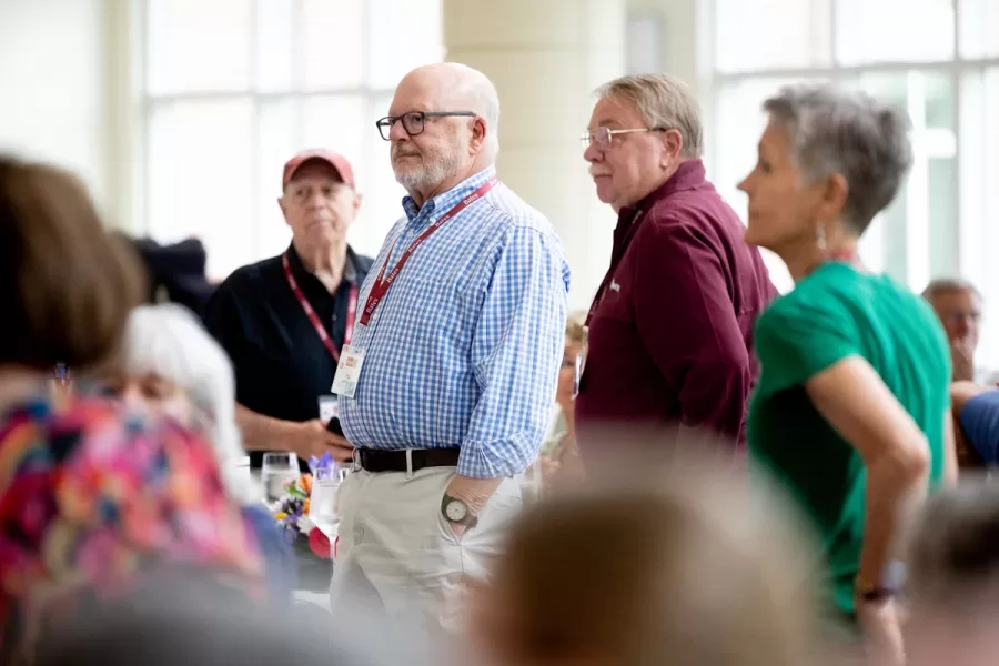 President Garry W. Jenkins addresses members of the Class of 1975 at their 50th Reunion Breakfast in Pettengill Hall’s Perry Atrium on June 6, 2025. He presented to awards: one, Bates Best,  to Susan Bourgault Akie ’75 P’08, and the other. The 2025 50th Reunion Philanthropic Leadership Award, posthumously, to John R. Hester ’75 whose brother Andy Hester (in green), nephew and Andy’s son Geoffrey Hester, John’s brother Mike Hester (in brown) with John’s wife Bronwen, accepted the honor.