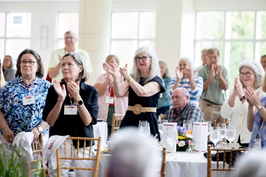 President Garry W. Jenkins addresses members of the Class of 1975 at their 50th Reunion Breakfast in Pettengill Hall’s Perry Atrium on June 6, 2025. He presented to awards: one, Bates Best,  to Susan Bourgault Akie ’75 P’08, and the other. The 2025 50th Reunion Philanthropic Leadership Award, posthumously, to John R. Hester ’75 whose brother Andy Hester (in green), nephew and Andy’s son Geoffrey Hester, John’s brother Mike Hester (in brown) with John’s wife Bronwen, accepted the honor.